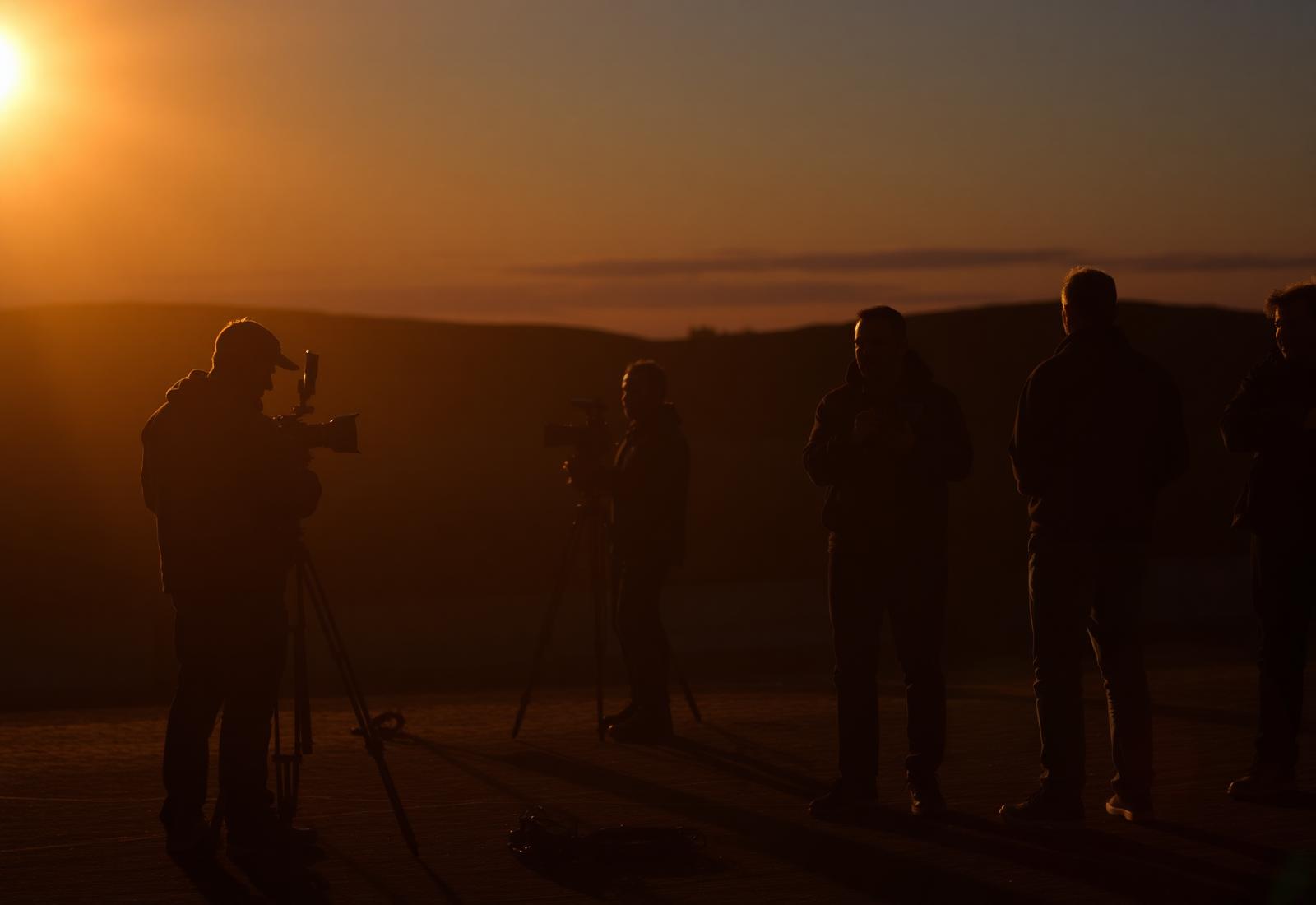 A documentary crew filming at golden hour